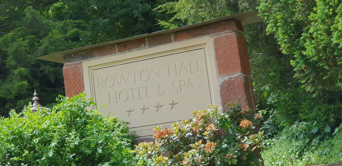 A sign for the Rowton Hall Hotel & Spa with a stone base and a clear name inscription.