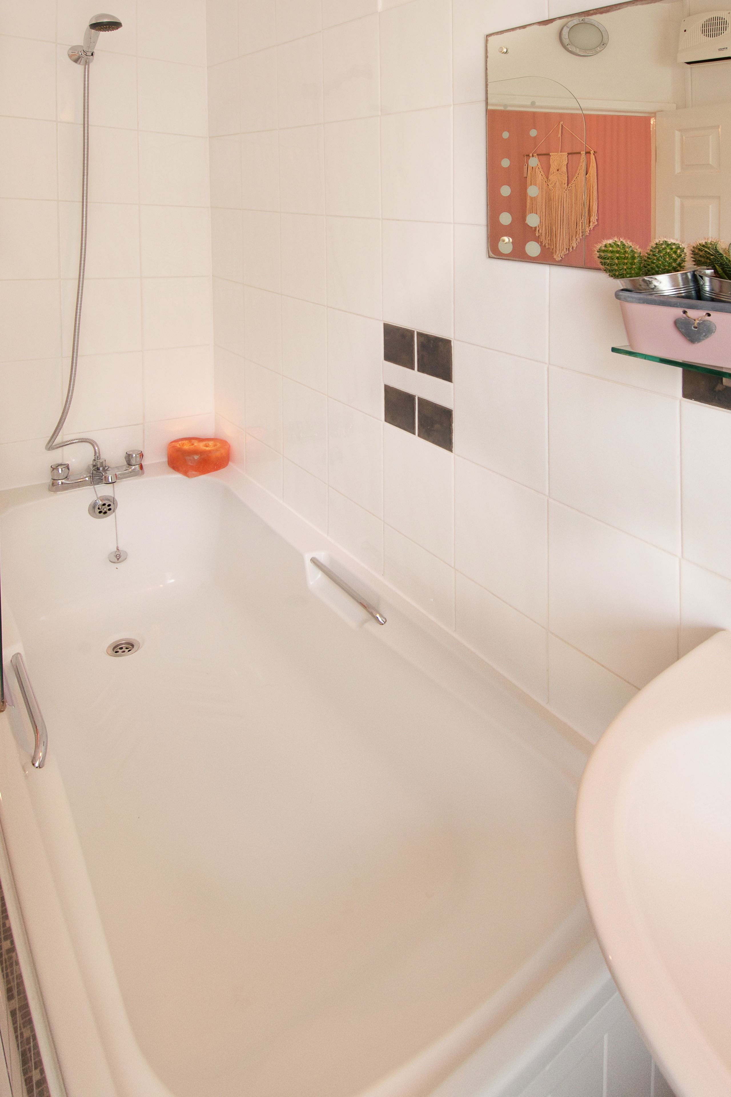 A bathroom with a bathtub, a shower, a sink, and a mirror.
