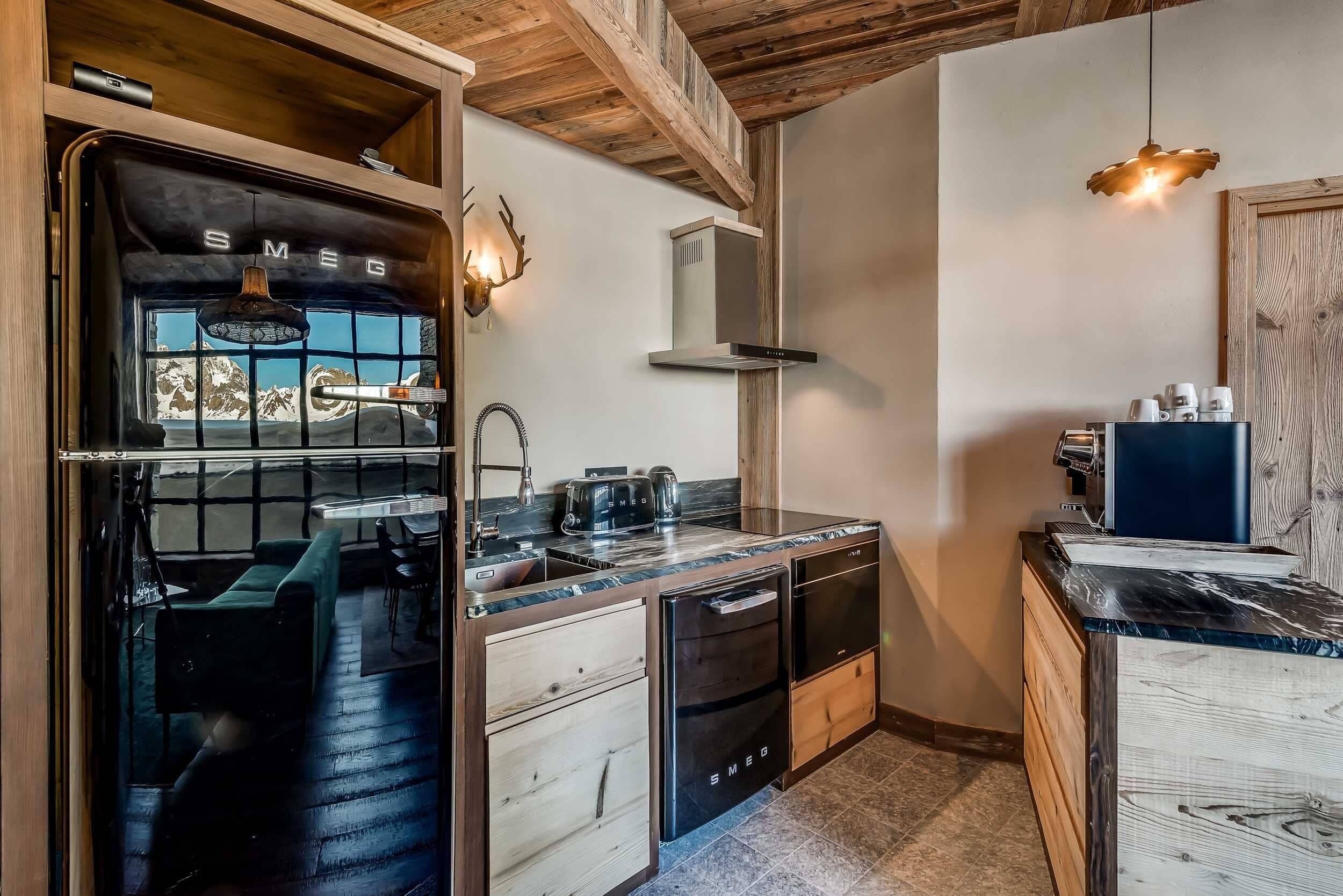 A compact kitchen with a built-in stove, a sink, and a countertop with a coffee machine.