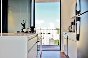 Enjoy cooking and city views in this kitchen with a gas stove, microwave, and coffee maker.