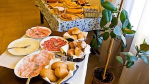 A buffet table with various food items and a potted plant. - Olistella (Palazzolo dello Stella)