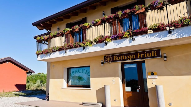 A building with a sign reading "Bottega Friuli" and a window with "SPACCF" on it. - Olistella (Palazzolo dello Stella)