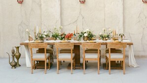 Een tafel voor zes personen, met een rustieke inrichting, omringd door stoelen met zachte zitplaatsen.