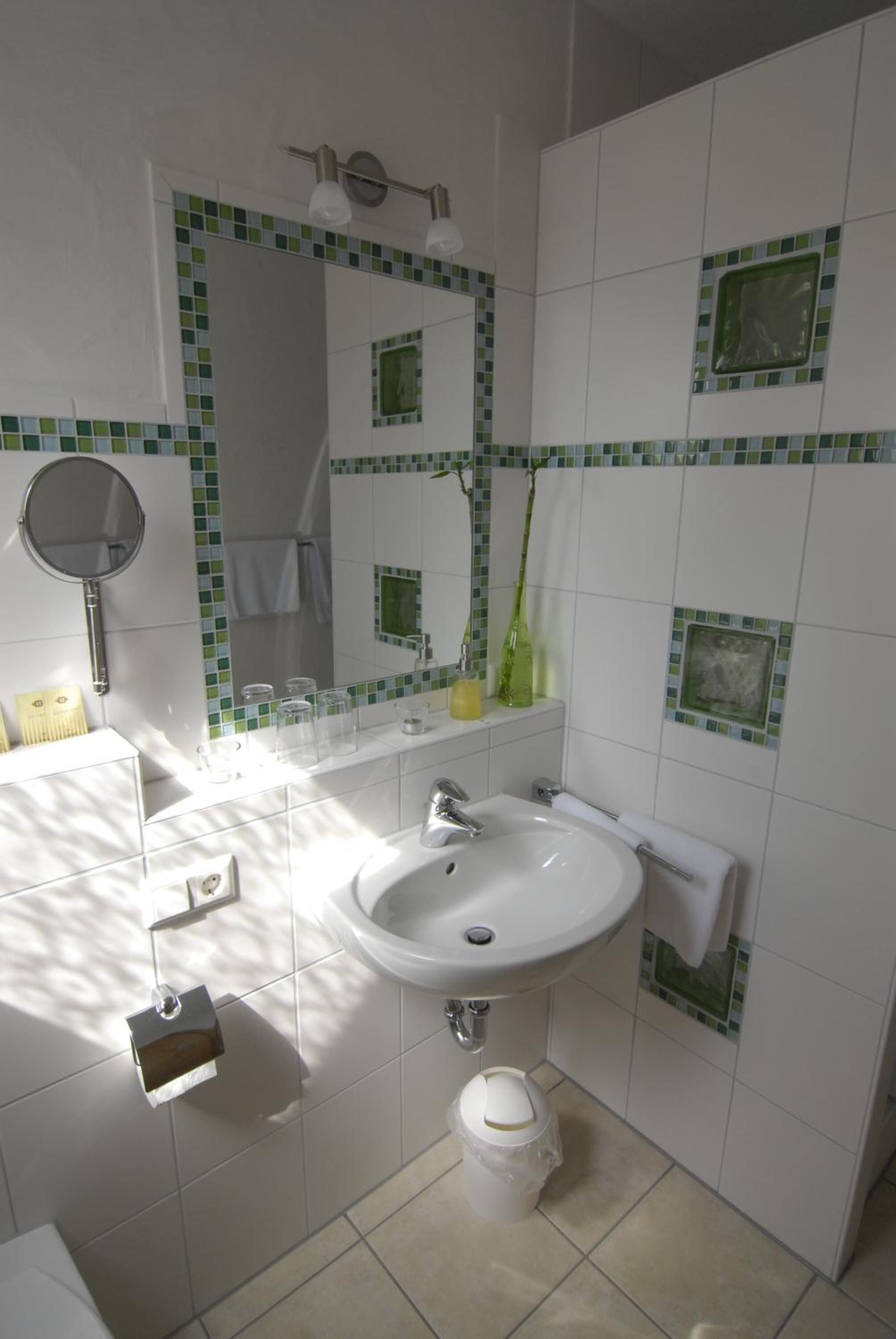 A bathroom with a white sink, a mirror, and a towel rack.