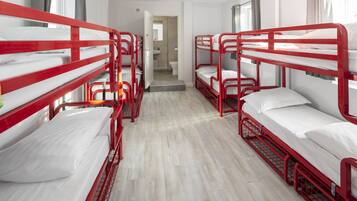 A room with bunk beds, a bathroom, and a hallway.