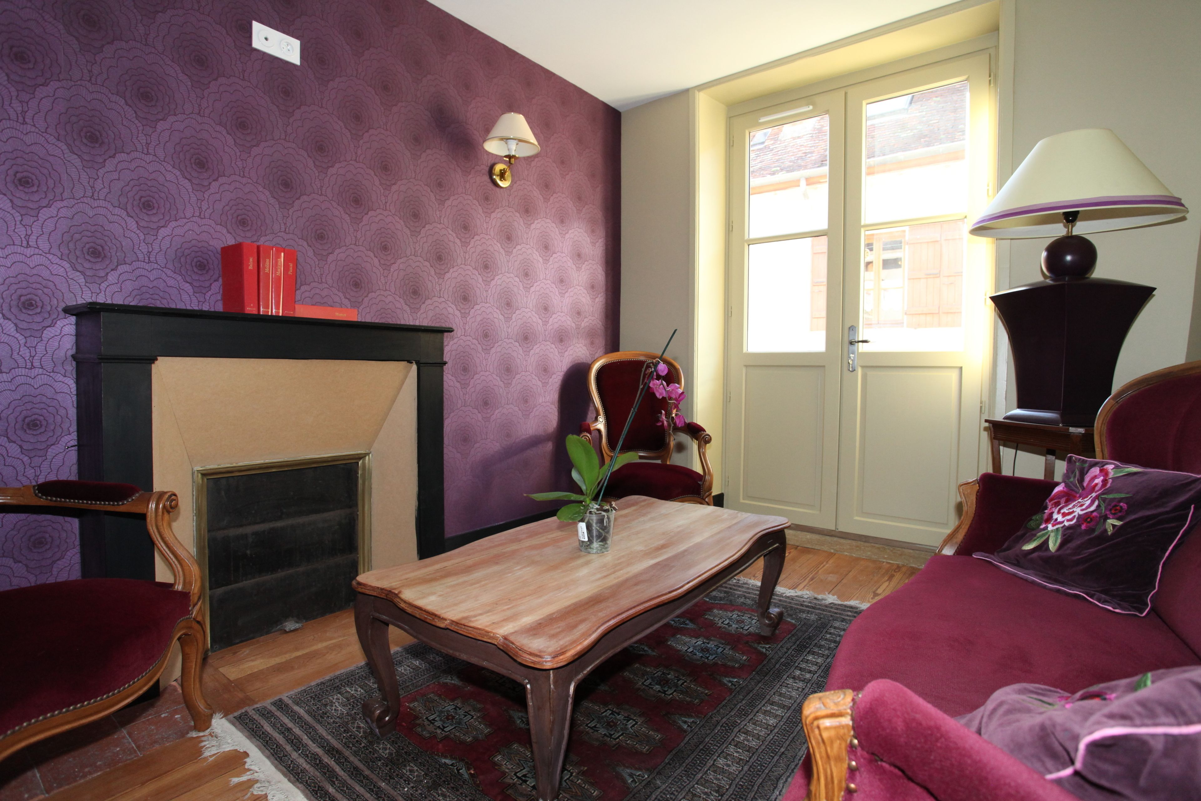 Una sala de estar con chimenea, un sofá, una mesa de centro y una lámpara.