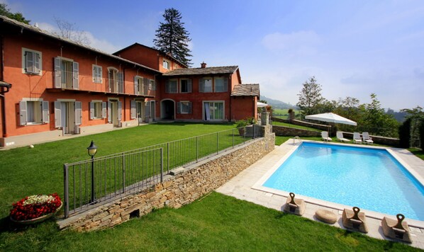 A large house with a swimming pool, stone walls, and a well-maintained lawn. - Cascina del Forte (Torre Pellice)