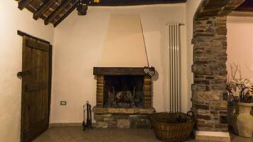 Una habitación acogedora con chimenea de piedra, puerta de madera y pared de piedra.