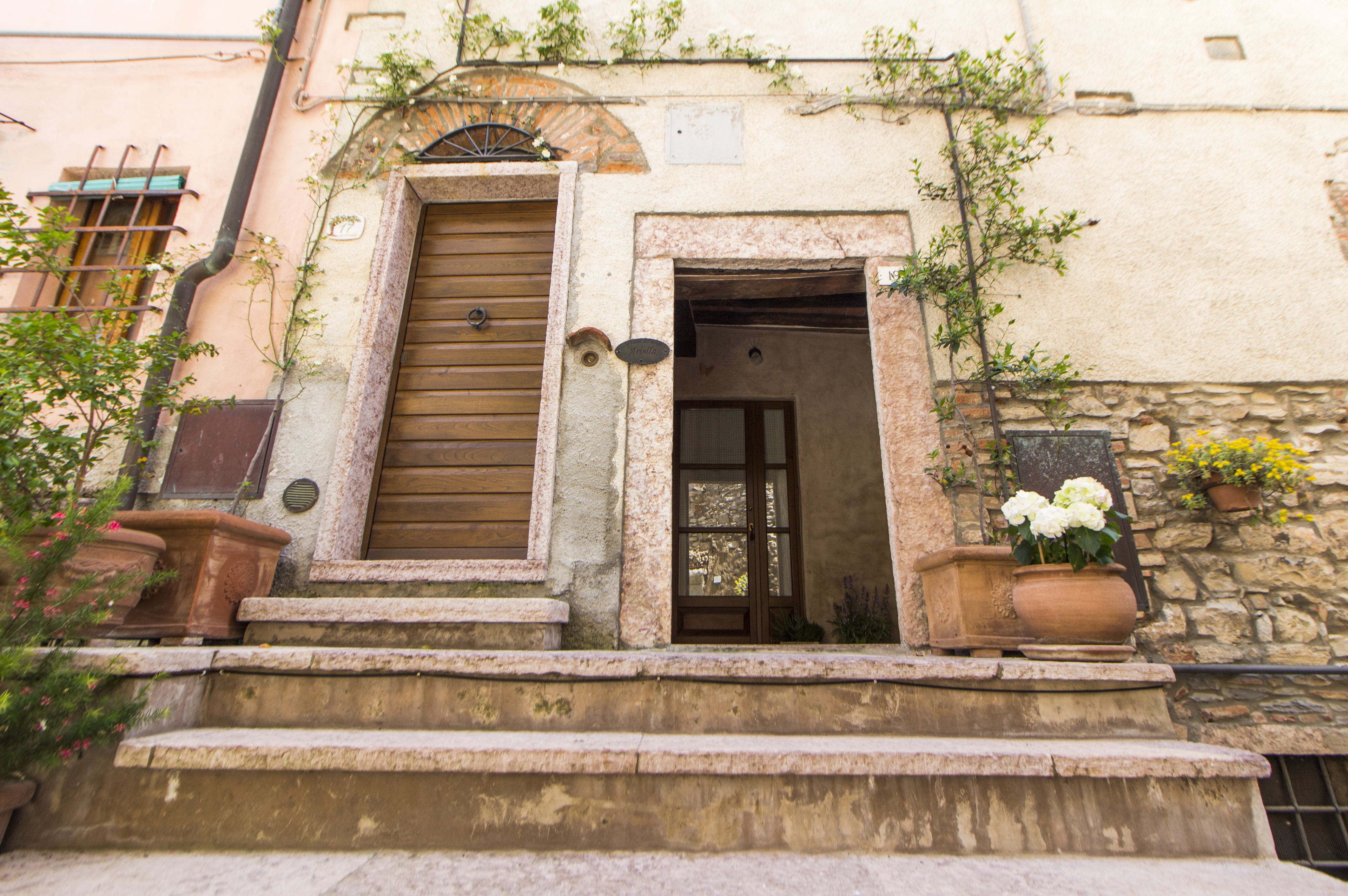 A stone building with a wooden door and steps leading to the entrance.