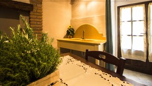 A bathroom with a wooden bench, a sink, and a potted plant. - Le Dame del Borgo (Sassetta)