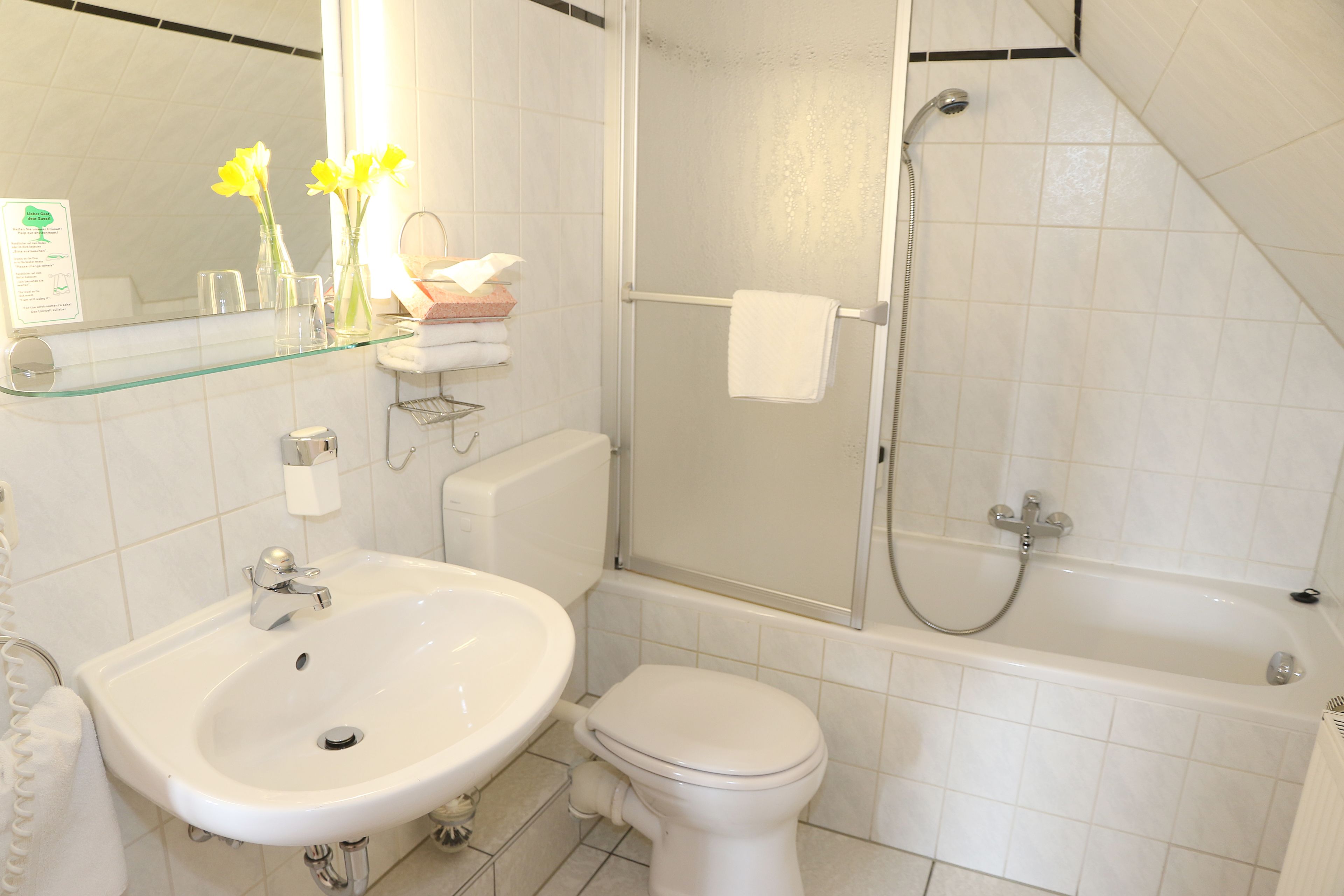 A bathroom with a sink, toilet, and shower.