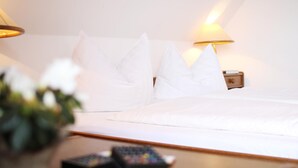 Een hotelkamer met een net opgemaakt bed, twee bedlampjes en een afstandsbediening op het nachtkastje.