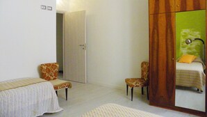 A bedroom with a bed, a wardrobe, a chair, and a bedside table. - B&B Al Ponte Vecchio (Perugia)