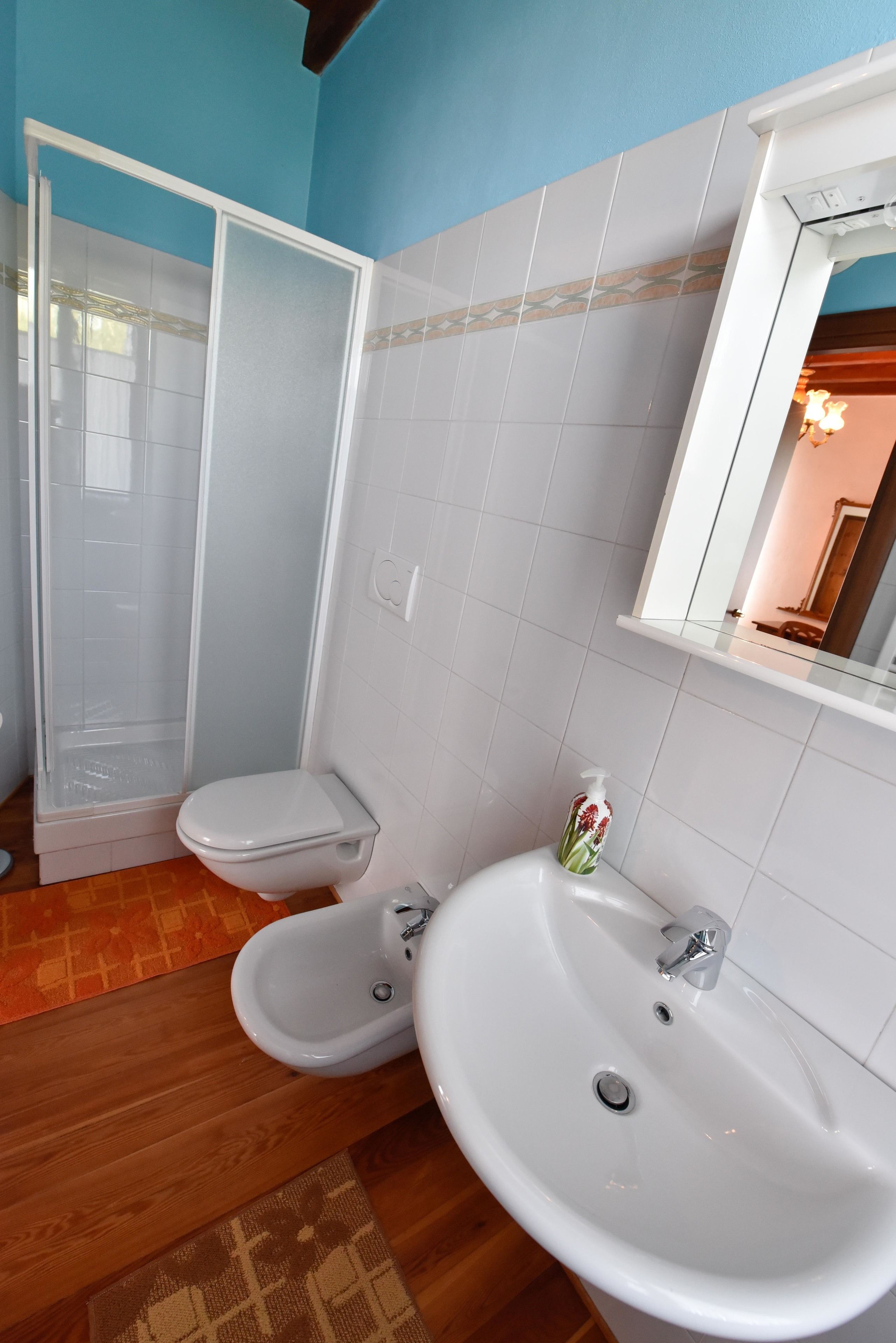A bathroom with a shower, toilet, and two sinks.