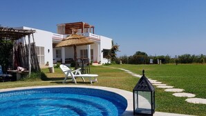 Eine moderne Villa mit Swimmingpool, Außenbereich und gepflegtem Garten.