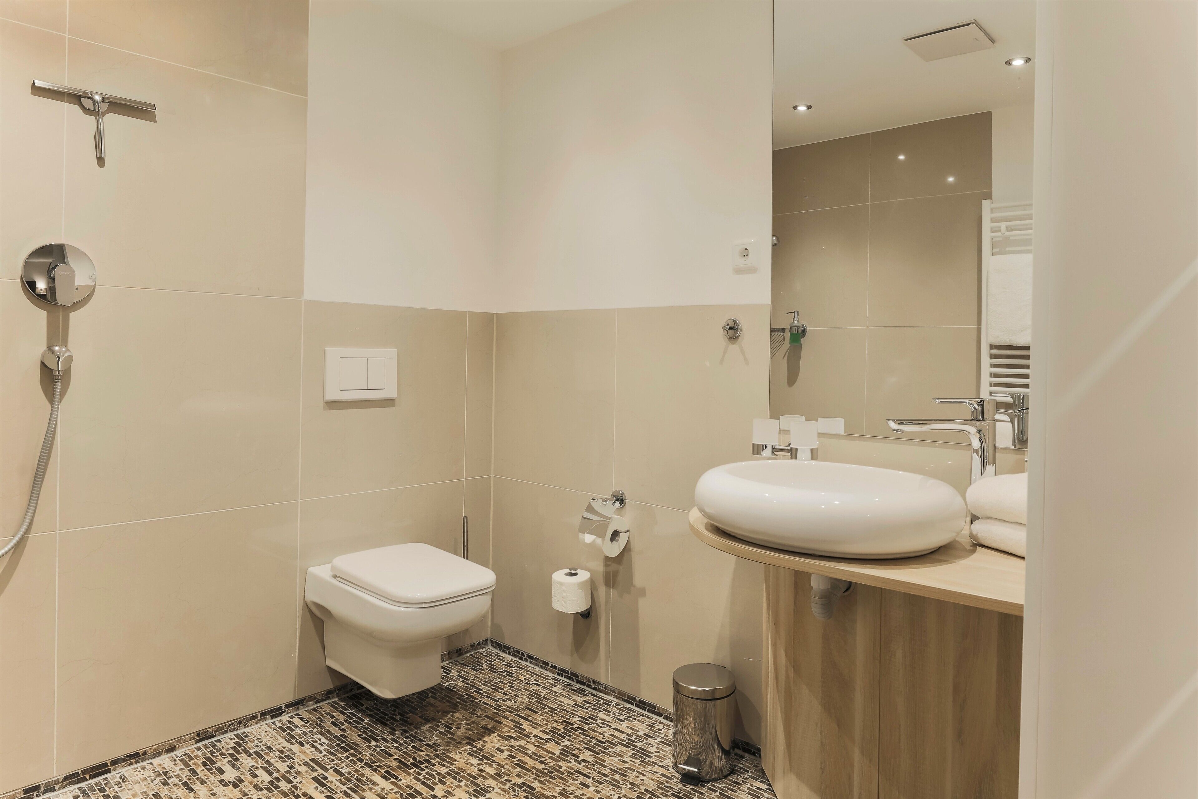 A modern bathroom with a toilet, bidet, and sink.
