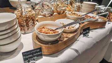 A buffet with various food options including fruits, nuts, and granola.