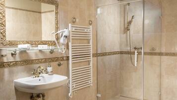 A bathroom with a sink, mirror, towel rack, and shower.