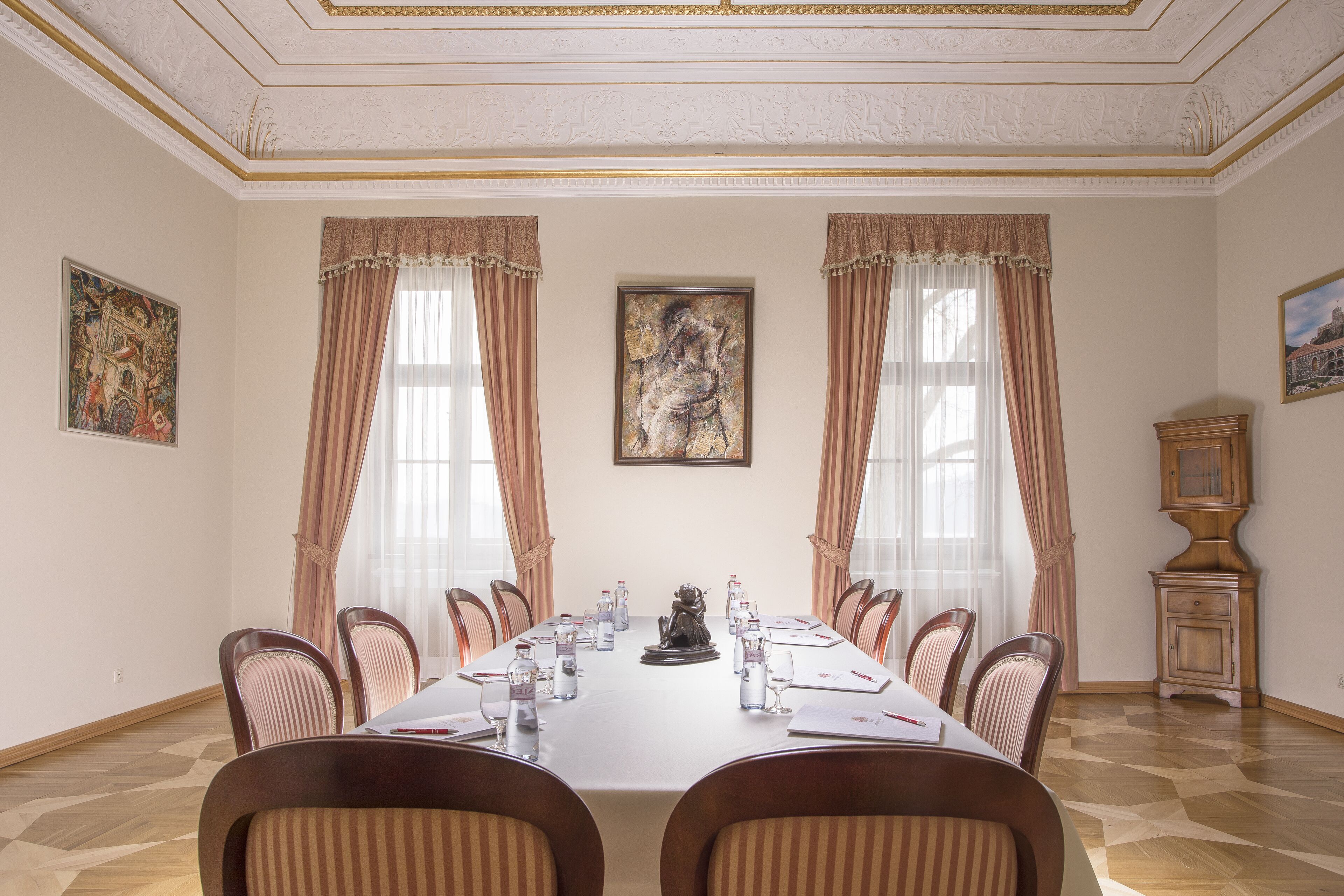 Un salón de conferencias con una mesa larga, sillas y un armario.