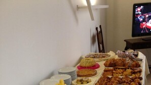 Un tavolo per buffet con diversi cibi, tra cui frutta, dolci e latticini.