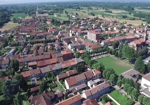 An aerial view of a residential area with closely packed houses, a central open space, and a prominent tower.