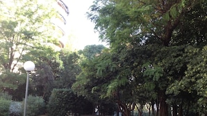 A park with a paved walkway, trees, and a lamp post. - B&B La Petite Maison (Marseille)