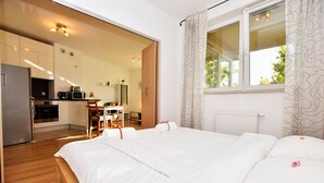 Une chambre d’hôtel moderne avec un grand lit, une petite kitchenette et une vue sur l’extérieur.