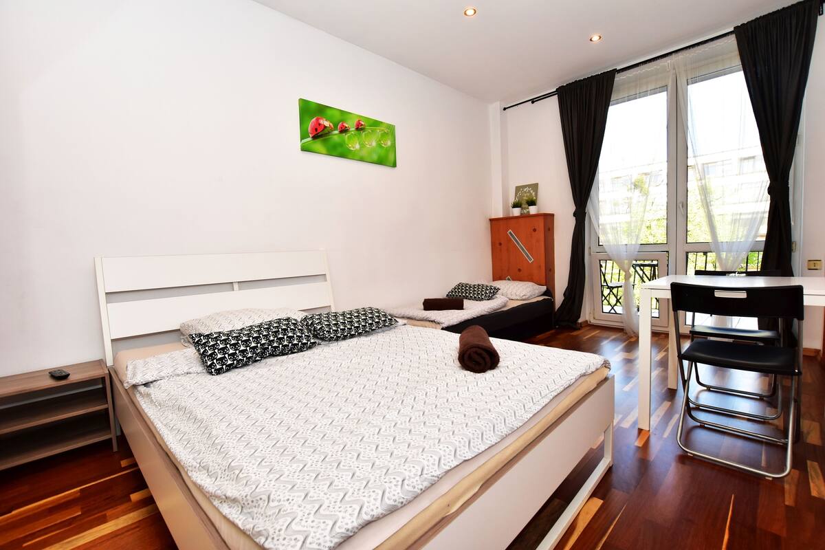 A bedroom with a bed, a desk, and a chair.