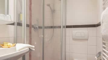 Une salle de bain moderne avec une douche à parois de verre, un lavabo blanc et des toilettes.