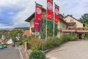 A building with multiple banners advertising a restaurant and hotel services. - Hotel Restaurant Martha (Wertheim)