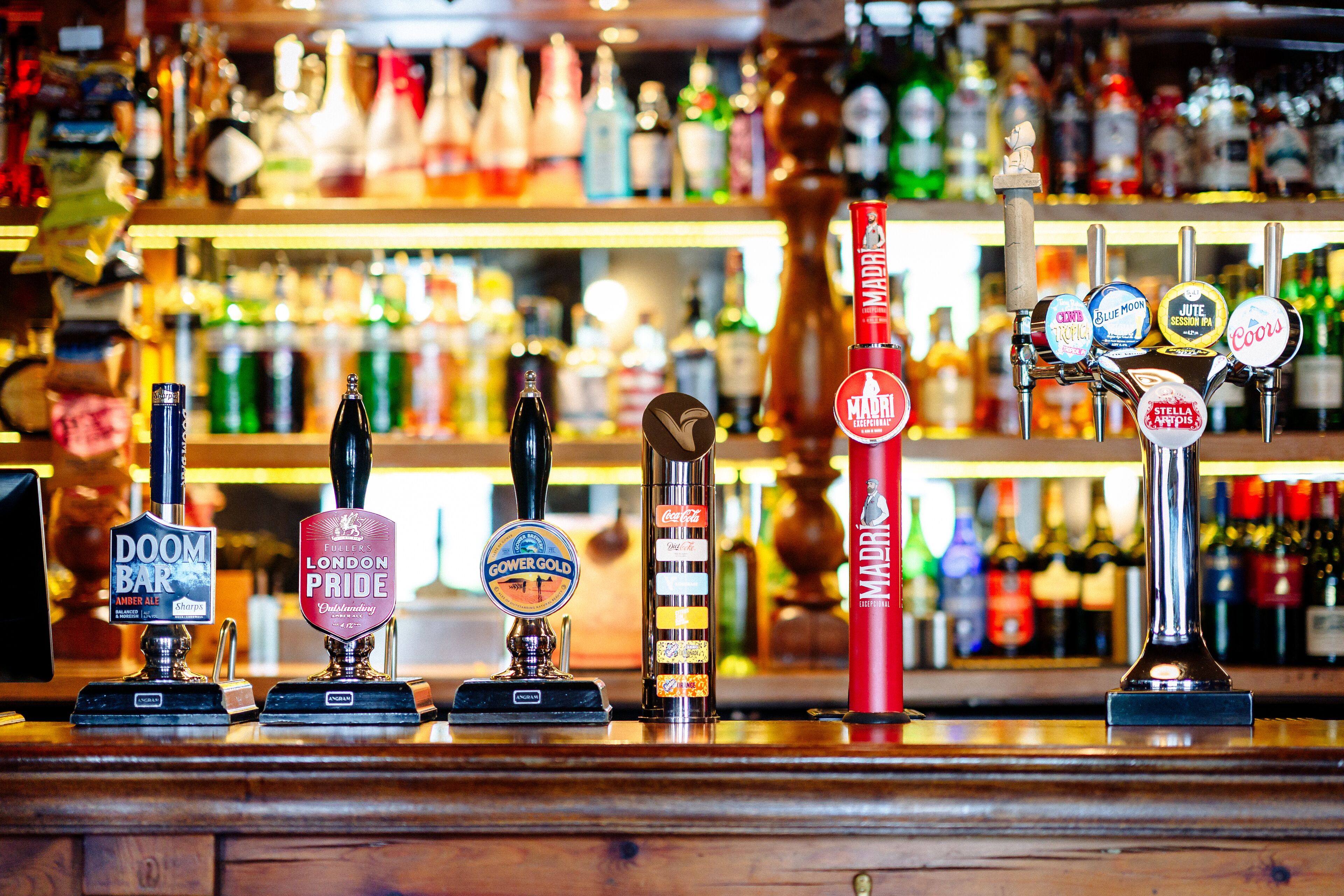 A bar with various beer taps and bottles in the background.