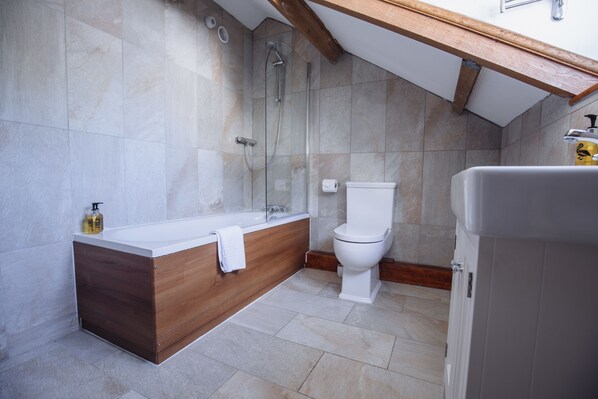 A modern bathroom with a wooden vanity, a bathtub, a toilet, and a shower. - King Arthur Hotel (Swansea)
