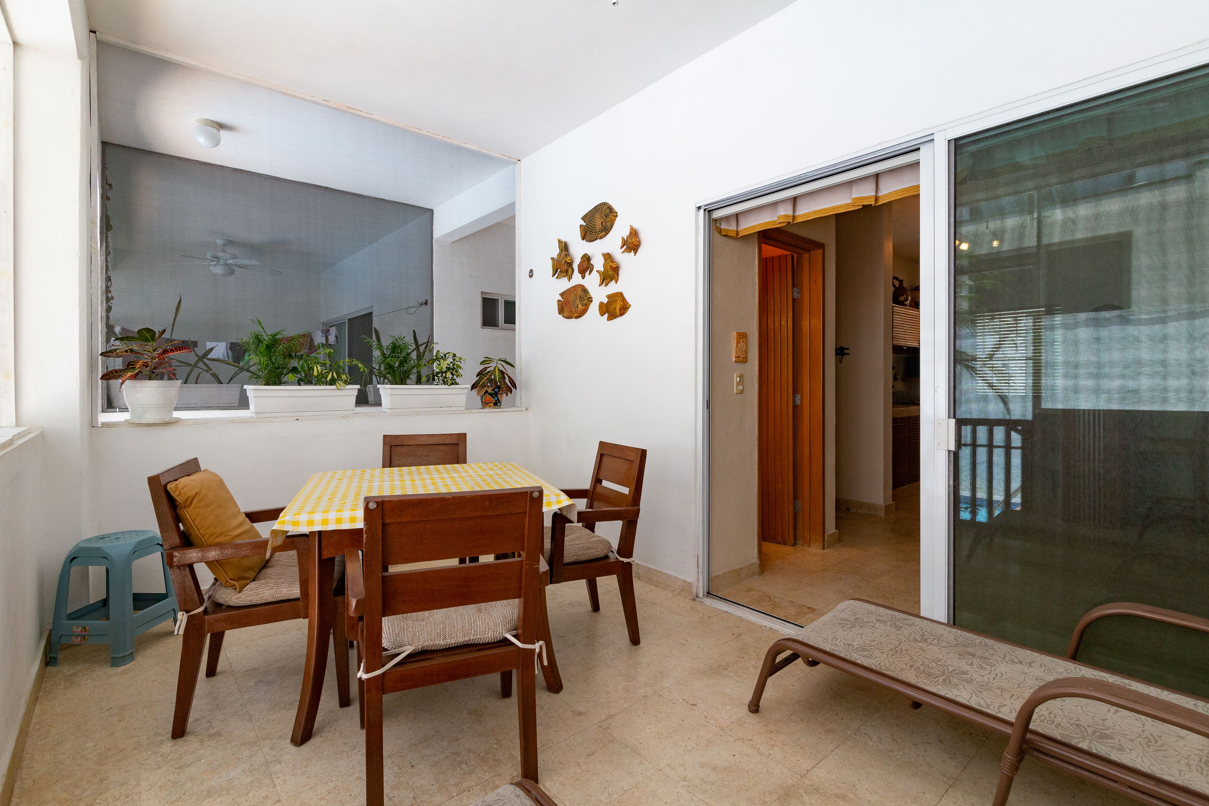 A dining area with a table and chairs, a small stool, and a bench.