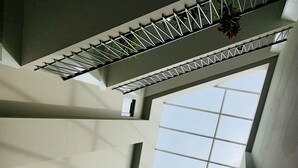 A high-ceiling atrium with skylights, a staircase, and a view of the sky. - PLS Apartments - Cantonments (Accra)