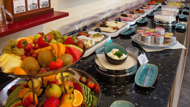 A buffet with various food items and a coffee station.