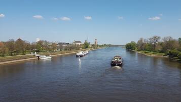 Un río con barcos y un puente al fondo.