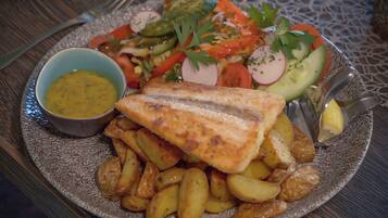 A plate with fish, potatoes, and a salad.