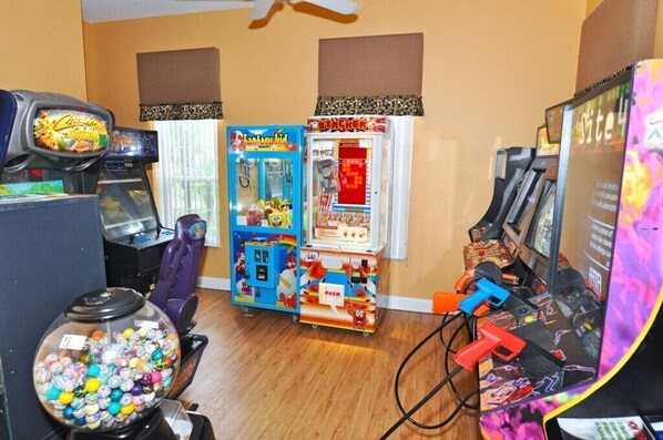 A room with arcade games, including Pac-Man and Donkey Kong, and a candy dispenser. - Emerald Island Resort 2676AEID - Five Bedroom House (Kissimmee)