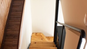 A wooden staircase with a metal handrail, leading to a white wall at the top. - Luxury Loft Lefkas (Lefkada)