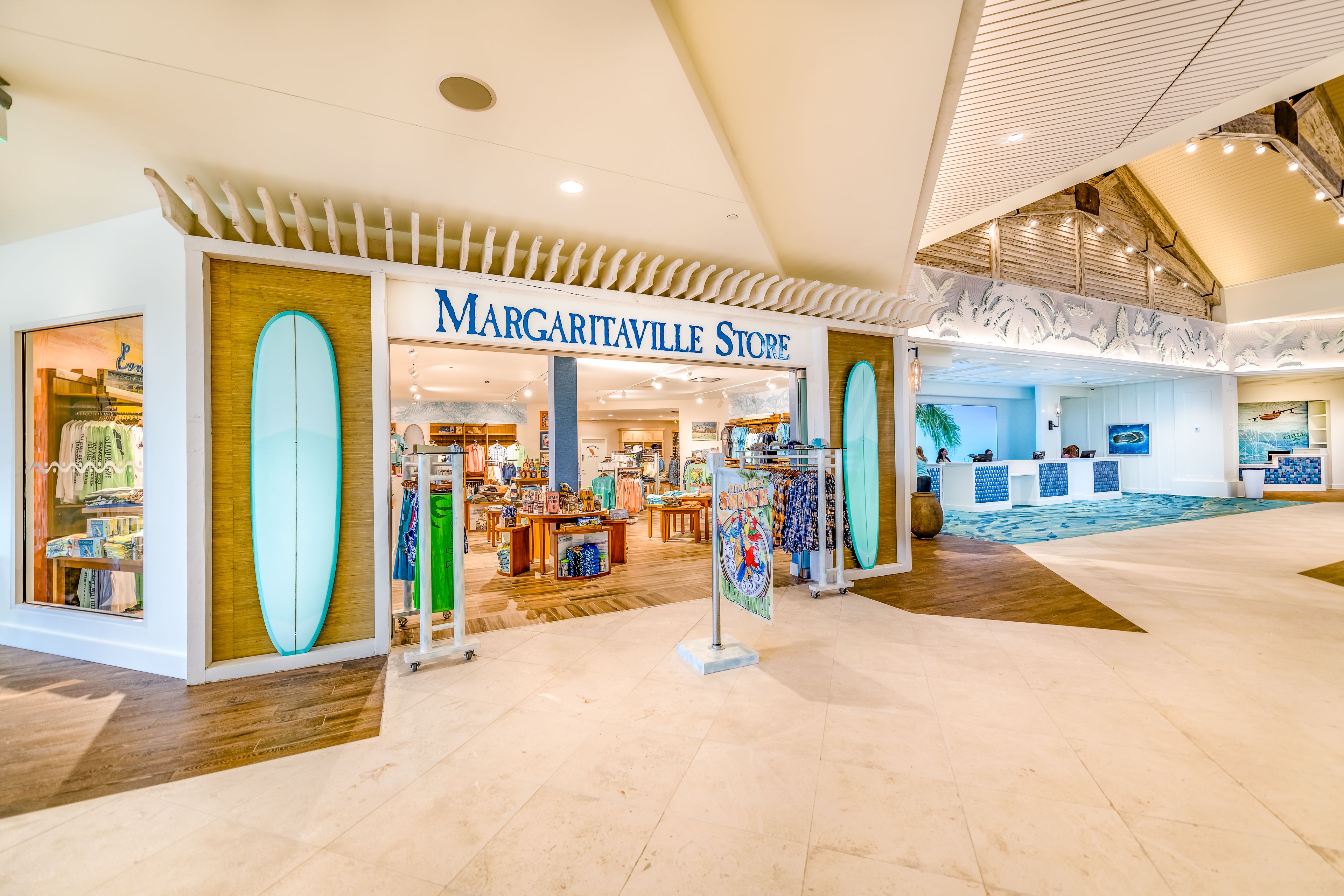 A spacious shopping area with a store named 'Margaritaville Store' featuring surfboards and beachwear.