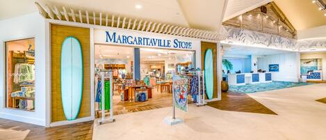 A spacious shopping area with a store named 'Margaritaville Store' featuring surfboards and beachwear.