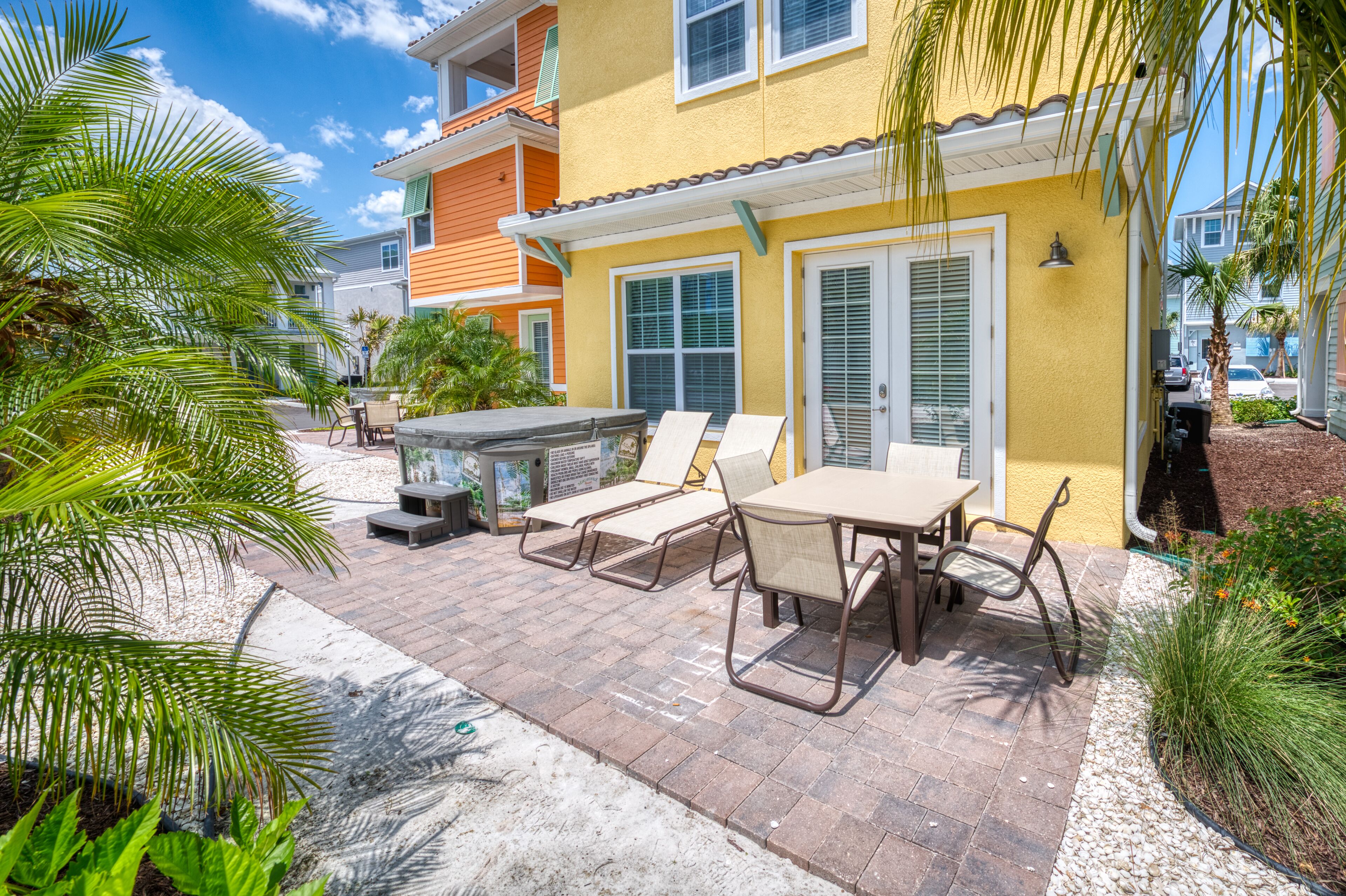 A patio with outdoor furniture, a grill, and a view of neighboring houses.