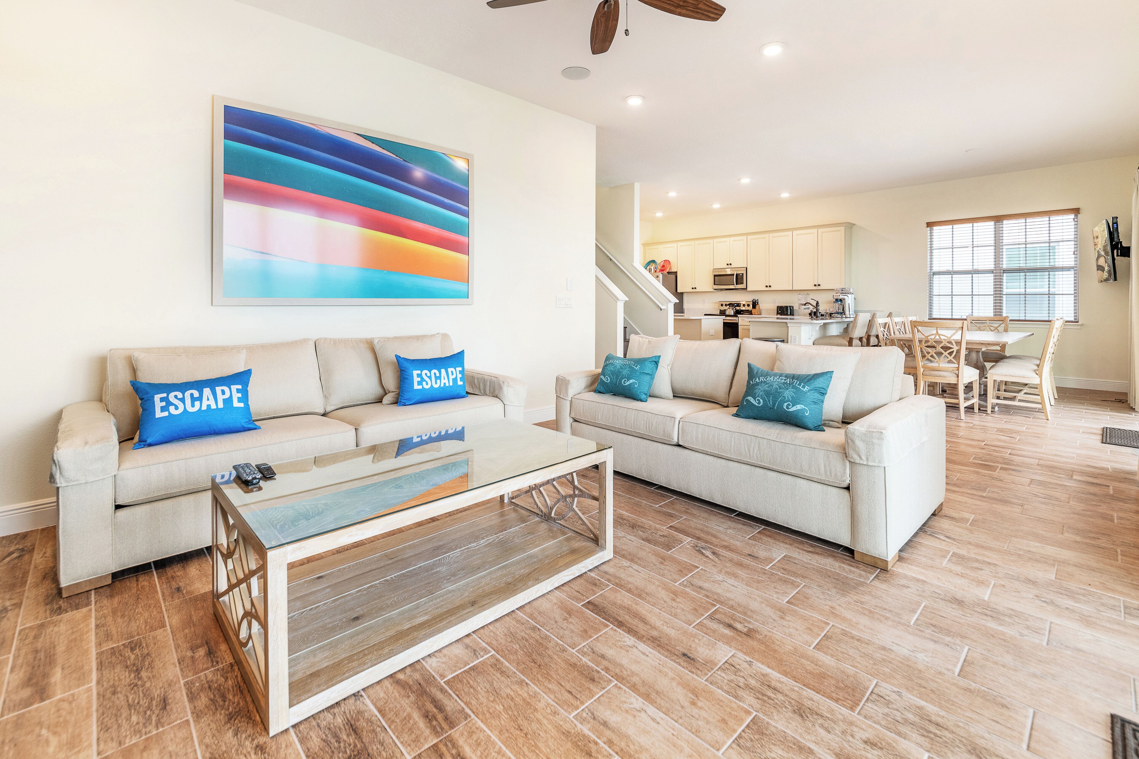 A spacious living room with two sofas, a coffee table, and a colorful abstract painting on the wall.