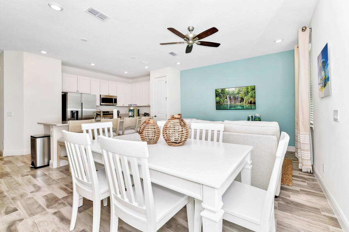 A modern kitchen with white cabinets, a microwave, and a stainless steel refrigerator.