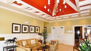 A spacious lobby with a red ceiling, framed artwork on the walls, and a chandelier. - Providence 2323EVDIL - Five Bedroom House (Davenport)