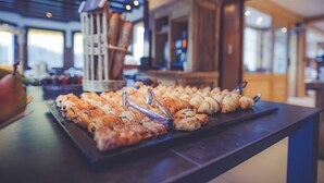 A buffet with various pastries and a coffee machine. - Fleur De Neige Hôtel (Chatel)