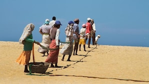 A group of people standing on a sandy beach with a clear blue sky in the background. - Kodev (Kalpitiya)