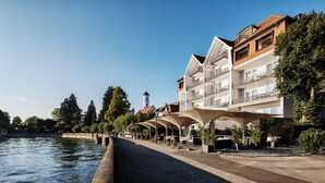 Un hotel frente al río con arquitectura moderna, vistas al río y zonas de estar al aire libre.