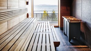 Un banco de madera y una mesa en una habitación con vistas al agua.