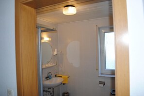 A bathroom with a sink, mirror, and window. - Landgasthof Gruß (Brilon)